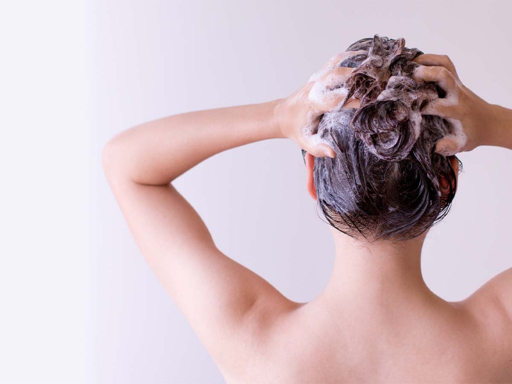 A woman shampooing her hair